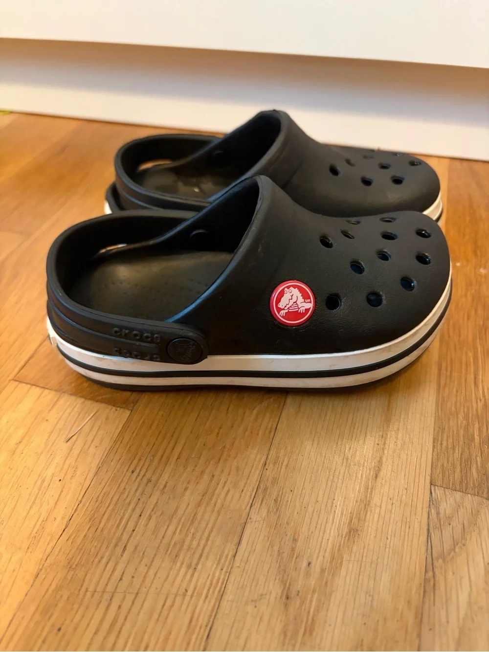 Kid’s black Croc slip on shoe with white band size 8